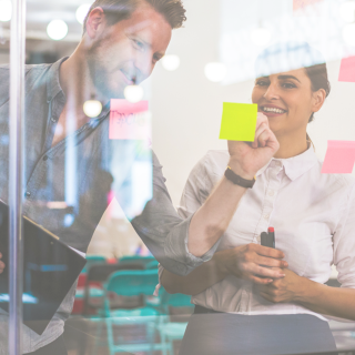 people with sticky notes at whiteboard
