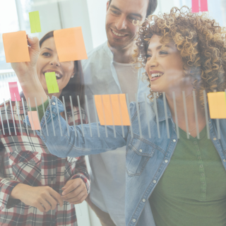 people working on white board with sticky notes